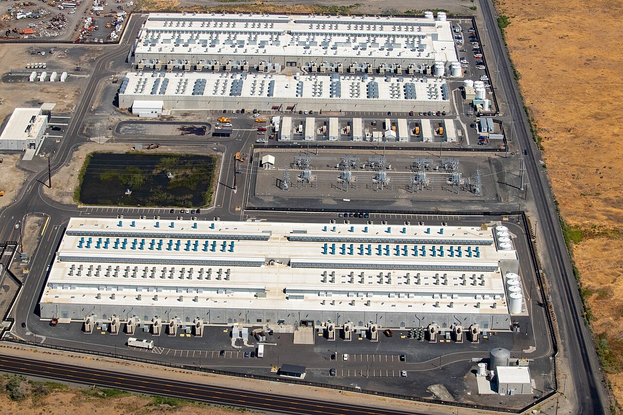 Aerial photograph of three AWS data-center buildings and their surrounding infrastructure in Oregon.